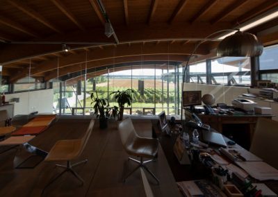 Interno di un ufficio direzionale con soffitto in legno lamellare e vetrata panoramica realizzato da Zini Elio S.r.l.