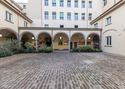 Cortile interno con porticato ad archi di un edificio storico restaurato da Zini Elio S.r.l.