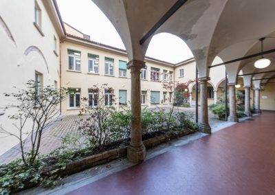 Cortile interno con porticato ad archi di un edificio storico restaurato da Zini Elio S.r.l.