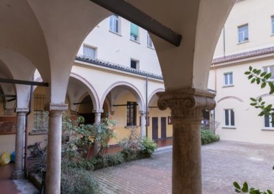 Cortile interno con porticato ad archi di un edificio storico restaurato da Zini Elio S.r.l.