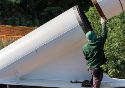 Operaio specializzato di Zini Elio S.r.l. impegnato nel montaggio di un grande tubo strutturale in acciaio bianco