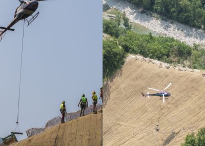 Elicottero in volo per il trasporto e la posa di materiali in un cantiere di consolidamento versanti di Zini Elio S.r.l.